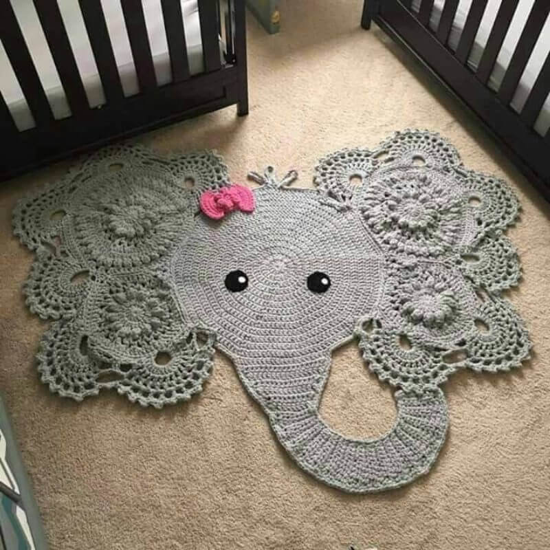 Вязаный коврик в виде слоника перед детскими кроватками