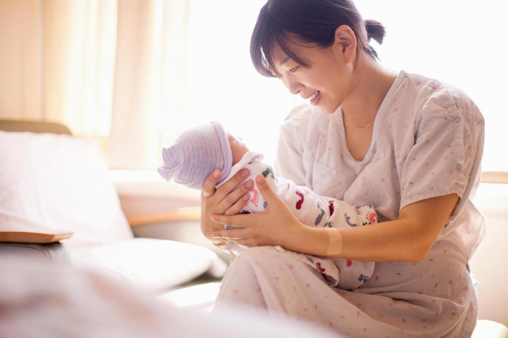 женщина держит на руках новорожденного ребенка
