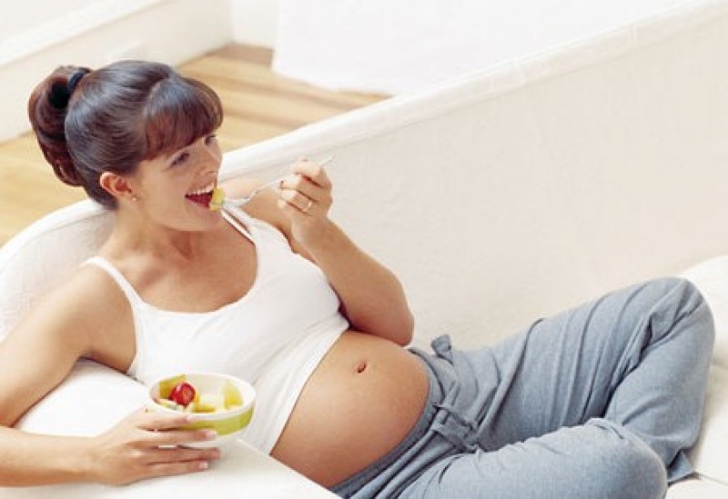 Беременная женщина кушает салат