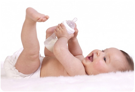 Ребенок с бутылочкой молока в руках