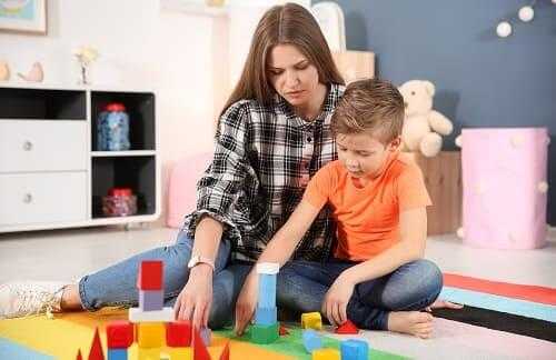 Ребенок аутист играет в игру с мамой